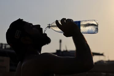 عامل يشرب الماء وسط موجة الحر في الإمارات